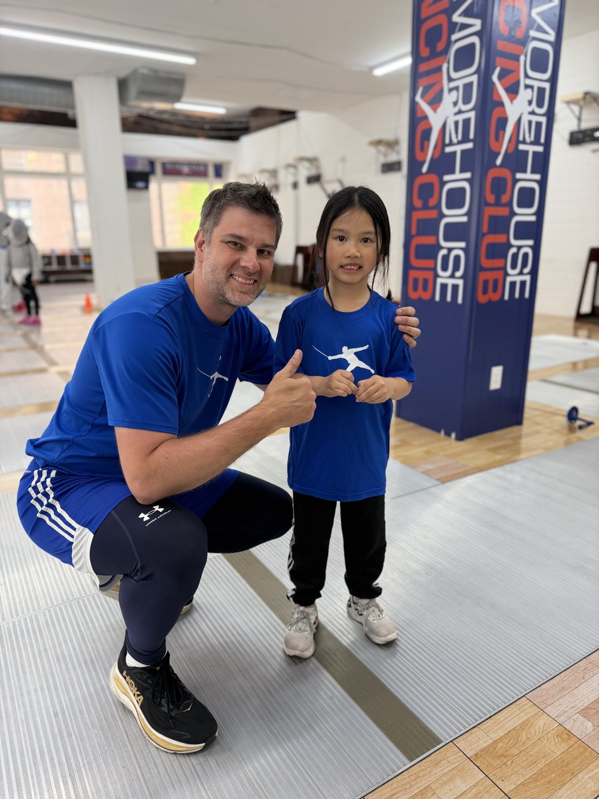 TMFC coach giving a thumbs-up with a smiling young fencer at the Port Chester training center near Rye NY